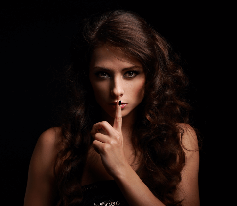 SydneyPI - SydneyPI - Discreet Silence Gesture: Confidentiality and Secrecy. A woman facing the camera with a finger to her lips, making a “shh” gesture to signal privacy and discretion.