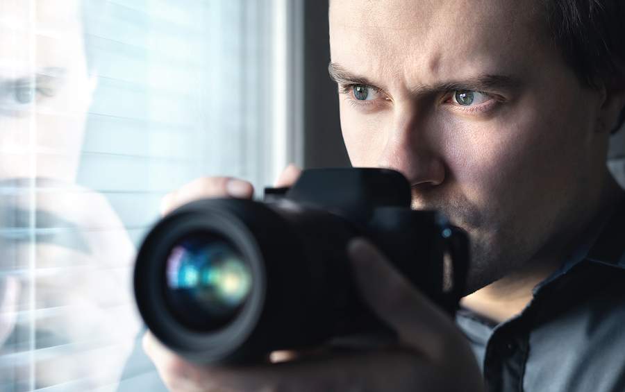 SydneyPI - SydneyPI - Private Investigator Holding a Camera and Looking from the Window